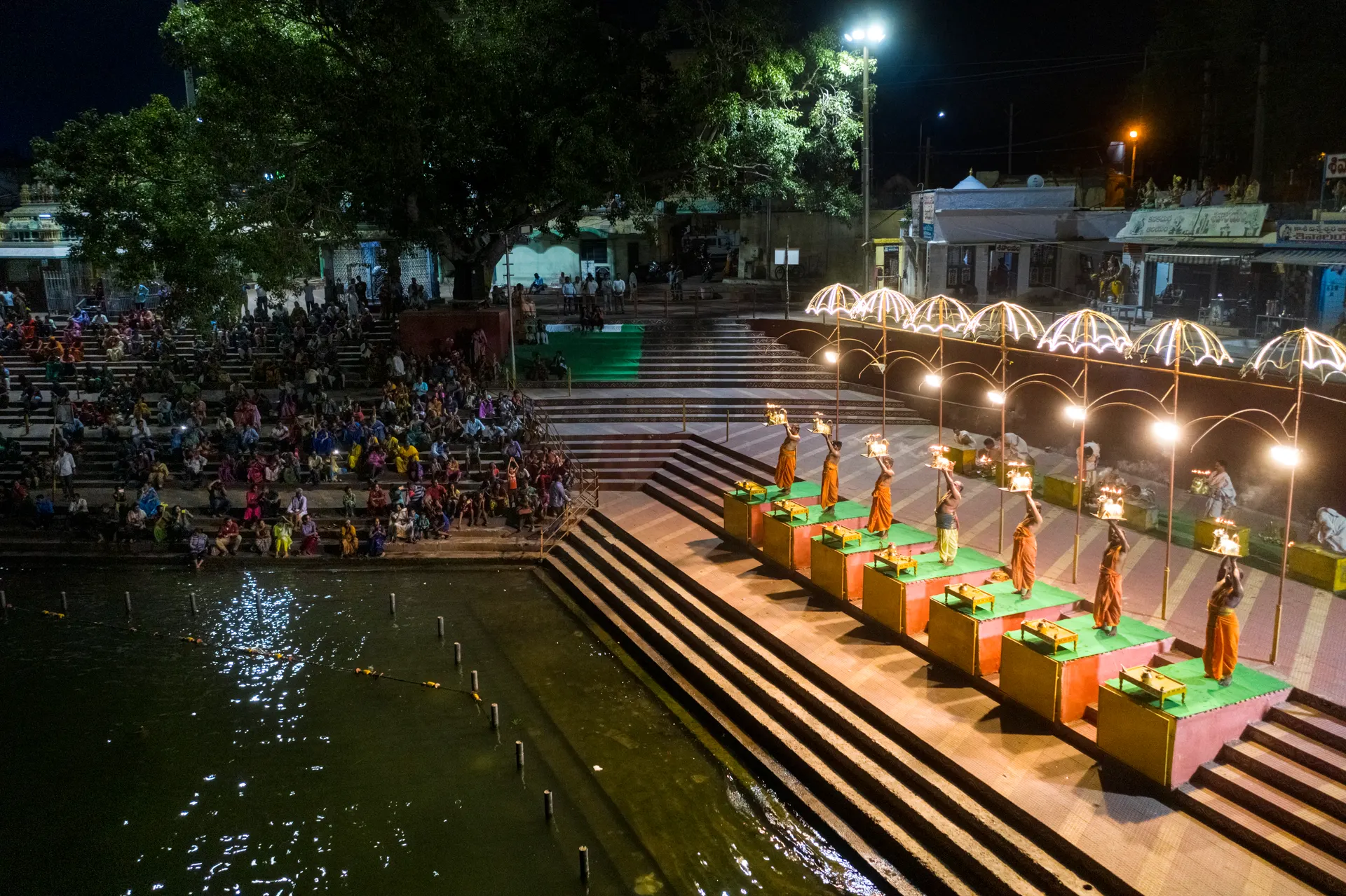 Priests raising lamps in the night Harathi on the ghat steps