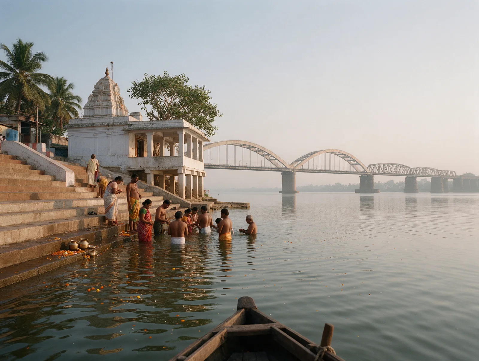 Pilgrims bathing at dawn on the Goshpada Kshetram ghat at Kovvur, the wide Godavari and the Rajamahendravaram bridges beyond.