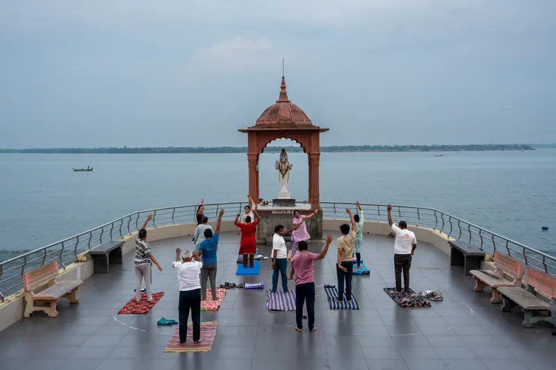 A morning yoga class stretching on a pavilion over the wide grey river